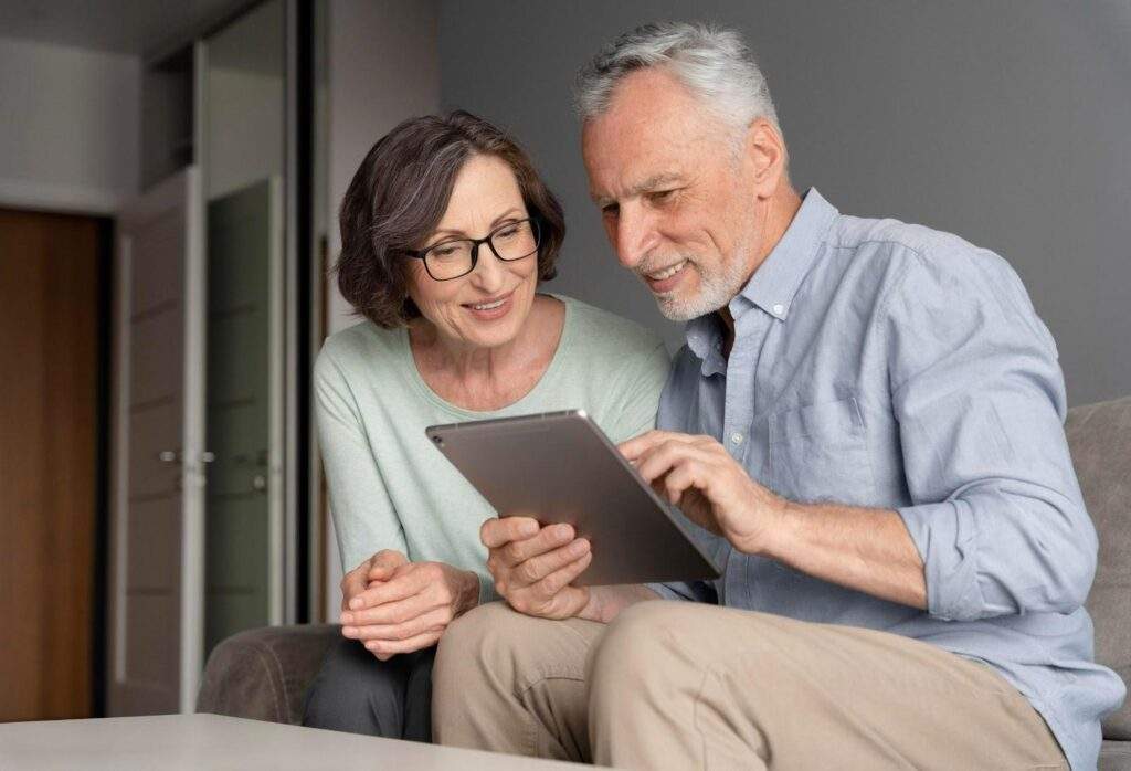 direitos-trabalhistas-apos-a-aposentadoria-7-fatos-que-voce-precisa-saber. Mulher e homem idosos acessando o tablet.