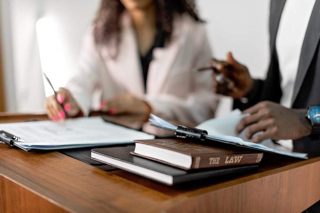 Advogado e cliente, um o lado do outro, sentados em uma mesa com papéis em cima, simbolizando a aposentadoria especial do INSS