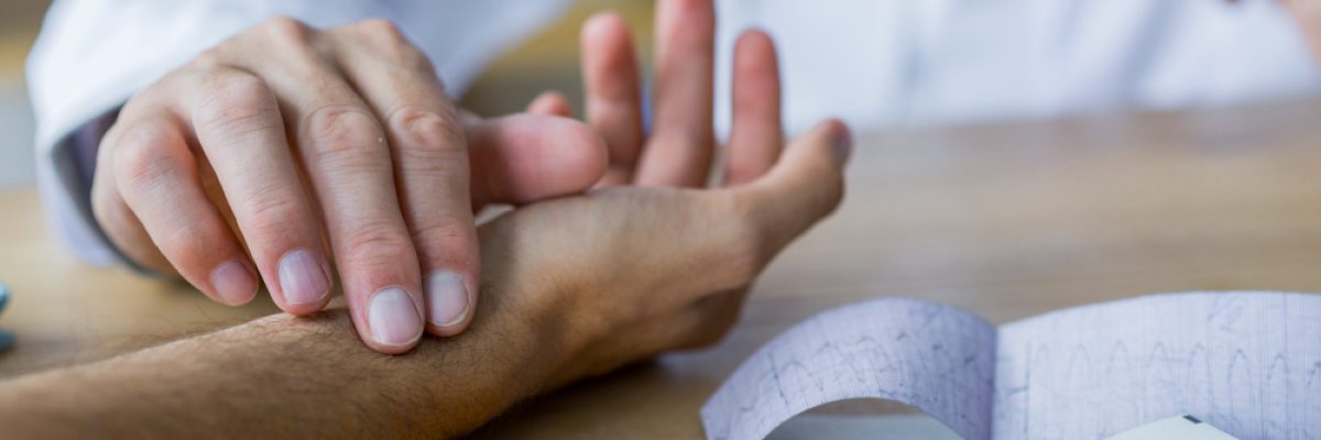 auxilio-doenca-do-inss-como-dar-entrada-neste-beneficio. Imagem: médico com a mão no pulso de um paciente em consulta.