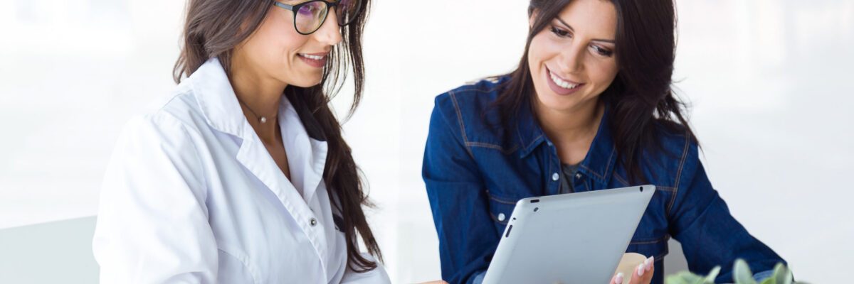 Portrait of doctor and her patient choosing mammary prosthesis in the office.